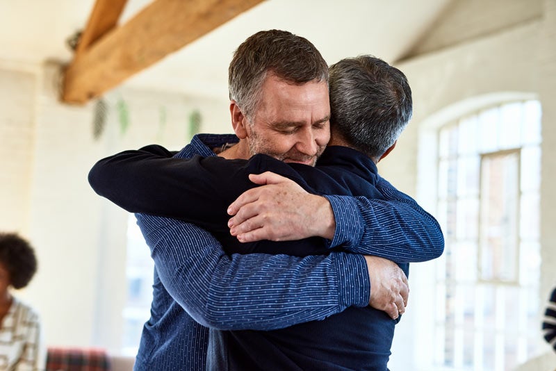 Two men hugging at support group